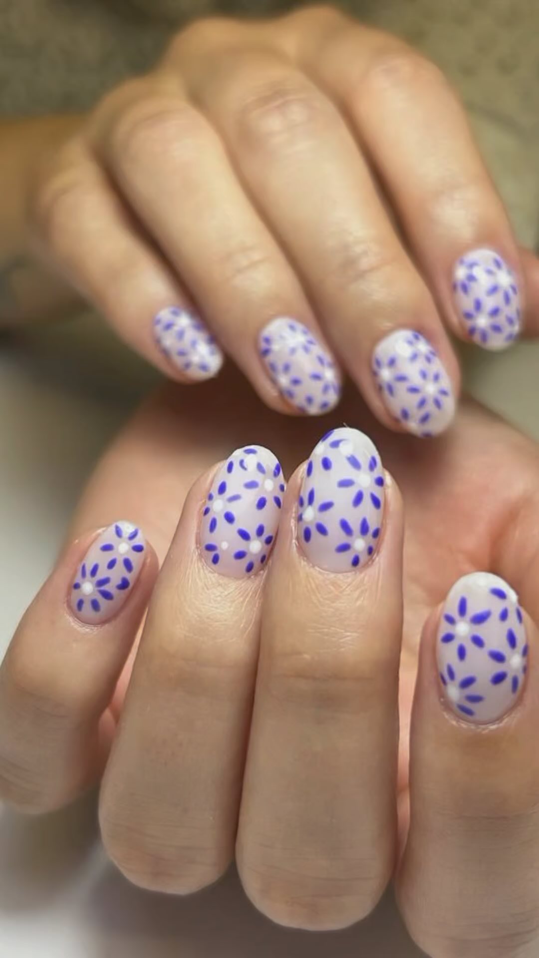 Nail art floral lila sobre base lechosa